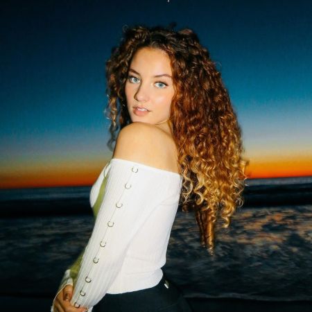 Sofie Dossi in white top at the beach posing for a photo